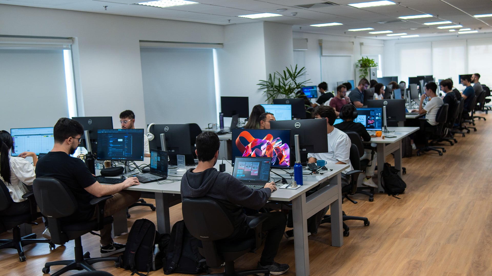 Mais de 20 profissionais a trabalhar nos seus computadores no escritório da Sioux